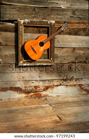 old decorative wooden frame with a acoustic guitar vertical
