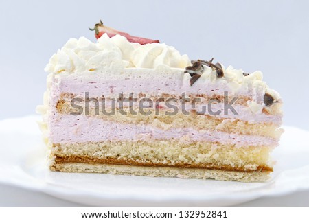 Slice of strawberry cream cake on the white plate