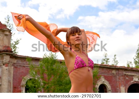 A young girl dances in a loss of old buildings