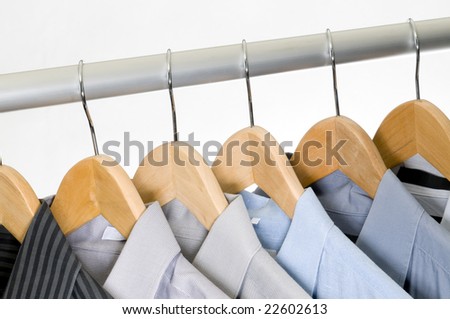 Dress shirts on wooden hangers.