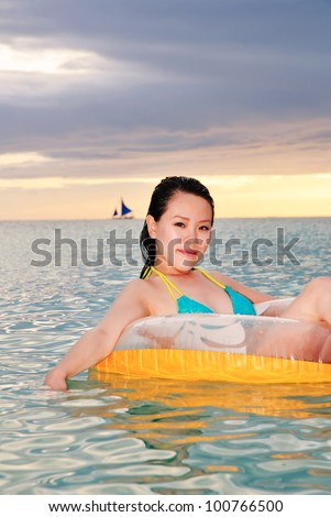 sexy brunette woman floating on pool toy