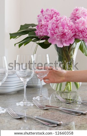 hand places wine glass at elegant table