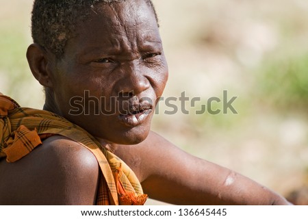 LAKE EYASI, TANZANIA - FEBRUARY 18: An unidentified Hadzabe woman looks pensively in the bush on February 18, 2013 in Tanzania. Hadzabe tribe threatened by extinction.