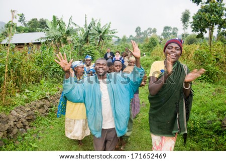 KISORO, UGANDA - DECEMBER 31, 2013: Unidentified pygmy people sing and dance in their village with unidentified tourists.