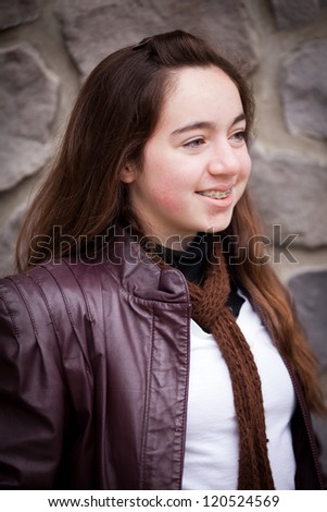 Beautiful young teenage girl with brown hair and brown eyes smiling off in the distance