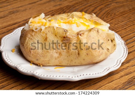 Baked potato topped with butter and cheese - top view