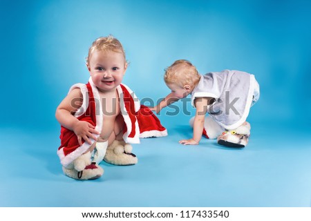 Portrait of a twins with blonde hair in vest and baby\'s bootees