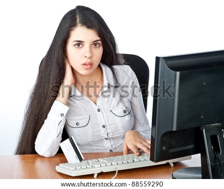 a beautiful young girl sits and works at the computer, surprise, isolated over white