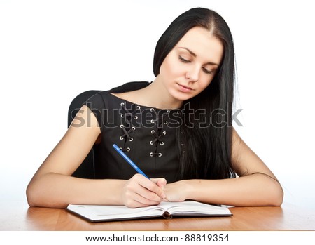 Young beautiful sexy brunette girl in black jacket with a notebook and pen in hand, isolated over white
