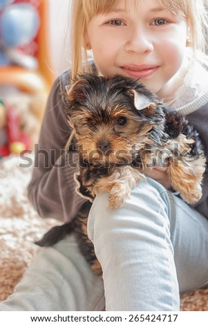 Little girl 7 years old hugging  Yorkshire Terrier 2 month