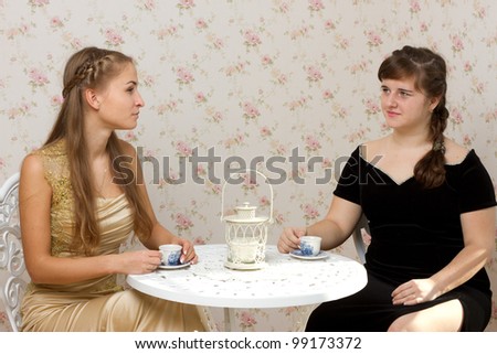 Two girls talking at a table in a cafe studio photography