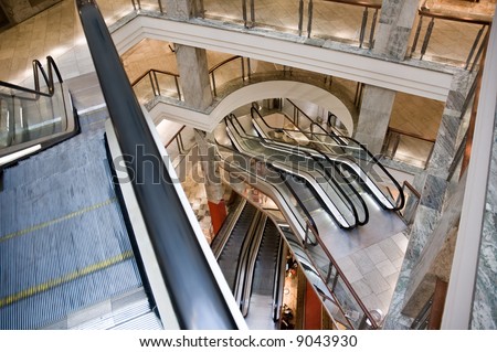 Escalators and marble floors of a luxurious mall. No people or ads.