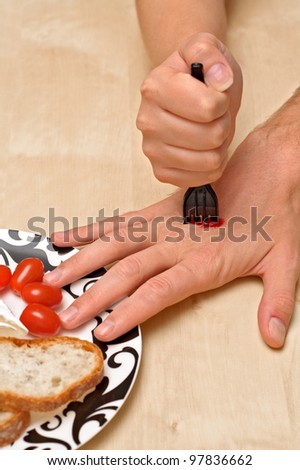 Woman\'s hand with a fork stabbs man\'s hand reaching the food.