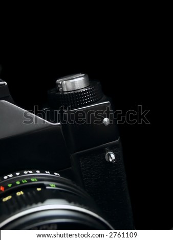 Old SLR camera isolated on black background
