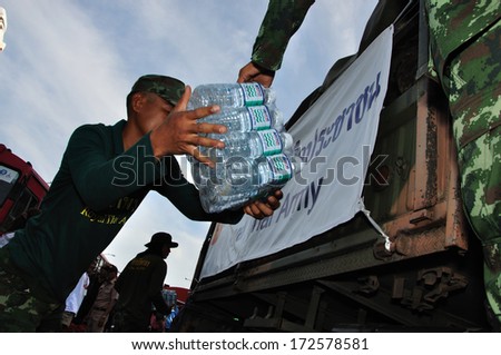 BANGKOK THAILAND- NOV 13: Unidentified soldier donate food and water for people on the bus on  flood street  on November 13, 2011 in Pra Pin Klao Brigde, Bangkoknoi, Bangkok, Thailand.