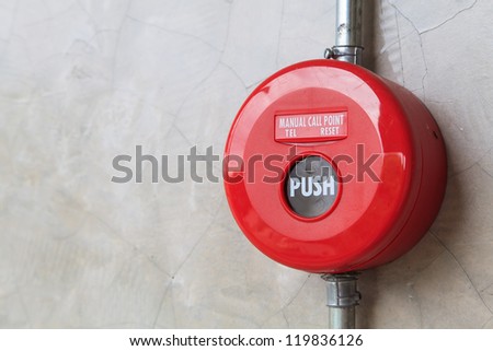 Red fire alarm mounted on the crack wall