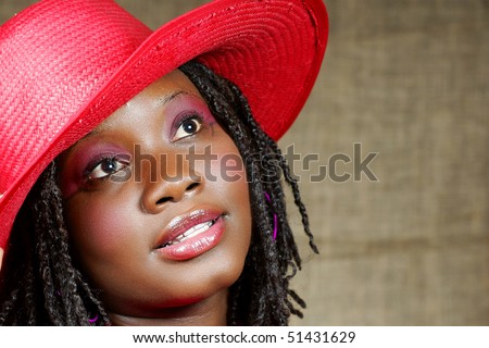 woman with red floppy hat looking up away from you
