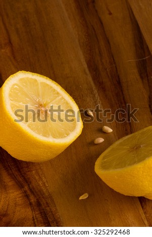 Two lemon halves and pips on wooden board background with copy space. Vertical, close up, selective focus