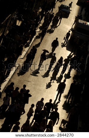 view from above of busy street with people walking silhouetted against golden light in rome italy