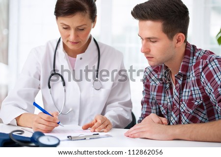 doctor talking to her male patient at office