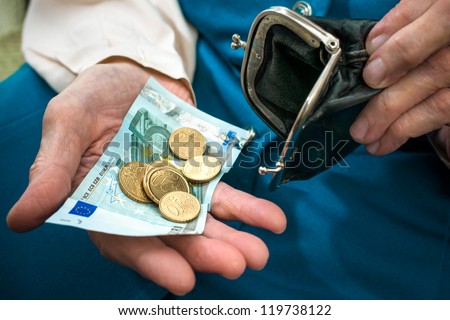 elderly caucasian woman counting money in her hands