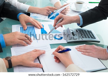 Closeup of human hands  over business documents at meeting