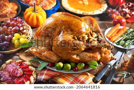 Thanksgiving turkey dinner. Roasted turkey on holiday table with pumpkins, pie, fruits, flowers and wine