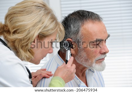ENT physician looking into patient\'s ear with an instrument
