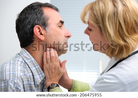 female doctor touching the throat of a patient in the office