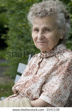 portrait of the elderly woman on the the park bench