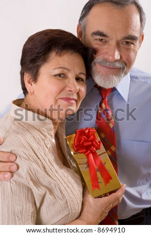 Elderly happy couple with gift