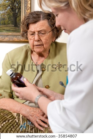 Senior woman is visited home by her doctor or caregiver at home. In the background is a picture from my portfolio