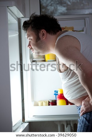 Fat man looking in the fridge
