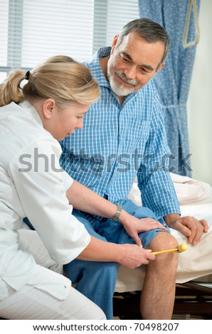 Physician checking reflexes of an old man in hospital