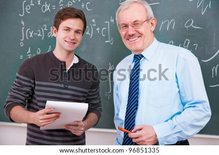 Student  with a teacher at the blackboard  in classroom