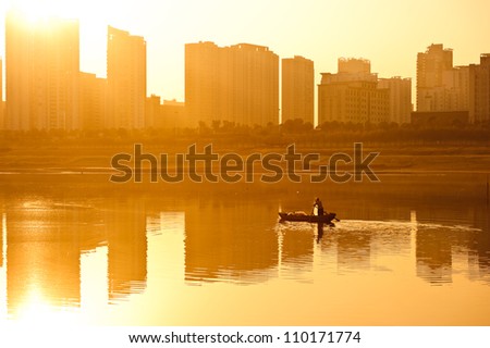 The setting sun city landscape, reflected in the lake