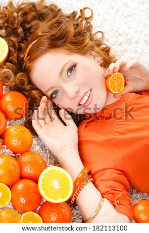 Beautiful close-up young red hair woman with oranges. Healthy food concept. Skin care and beauty. Vitamins and minerals.