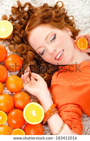 portrait of Beautiful close-up young red hair woman with oranges. Healthy food concept. Skin care and beauty. Vitamins and minerals.