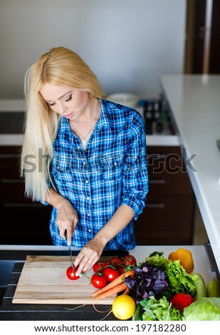 Happy smiling woman in kitchen with fresh produce vegetables preparing for a healthy meal