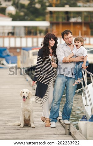 Happy family resting at beach in summer. Happy family with dogs on berth in summer