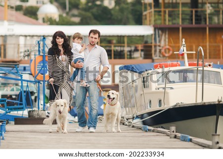 Happy family resting at beach in summer. Happy family with dogs on berth in summer