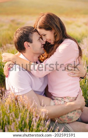 Young beautiful sensual couple outdoor kiss in windy weather in summer corn field. Young couple in love outdoor.Stunning sensual outdoor portrait of young stylish fashion couple posing in summer field
