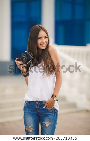 female photographer with professional SLR camera, natural light, selective focus on nearest part of lens with blend. beautiful girl photographed in the old camera