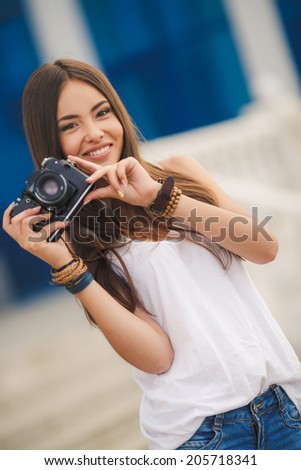 female photographer with professional SLR camera, natural light, selective focus on nearest part of lens with blend. beautiful girl photographed in the old camera