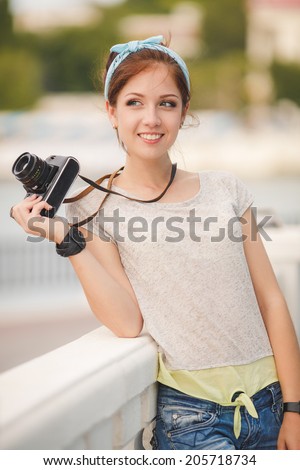 Young woman with camera outdoors portrait. Soft sunny colors. woman with vintage retro camera having fun playful laughing