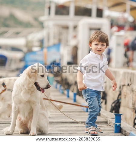 Child lovingly embraces his pet dog. Child walking alone with her lovely dog at beach