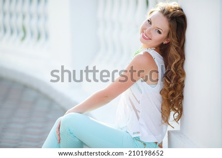 Beautiful young woman with long hair pictured turning head as beams of light capture moisture and mist in air. Portrait close up of young beautiful woman, on green background summer nature.