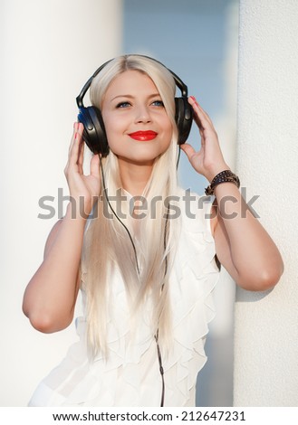Beautiful young woman with headphones. Enjoy music outdoors.
