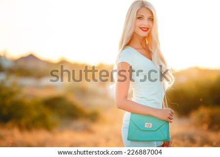 Young and beautiful woman wearing a hat in sunset light. Happiness woman stay outdoor under sunlight of sunset