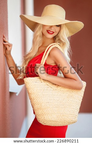 Sexy young beauty woman in red dress. beautiful fashionable blonde woman in red dress in hat with bag